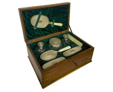 In an elegant wooden box. Consisting of 8 pieces: 3 brushes, 1 mirror, 1 comb, 3 perfume bottles.   