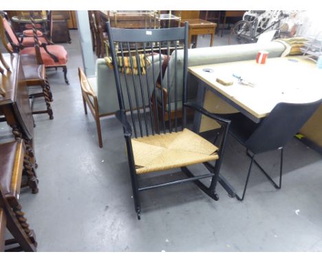 A STYLISH ART DECO EBONISED ROCKING CHAIR WITH STICK BACK AND RUSH SEAT 