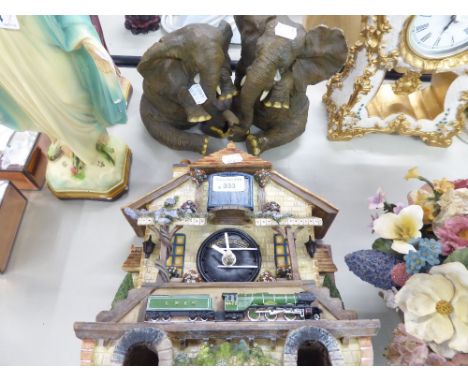 A RESIN WALL HANGING AUTOMATON CLOCK 'FLYING SCOTSMAN' AND A RESIN GROUP OF TWO ELEPHANTS SEATED CRYING