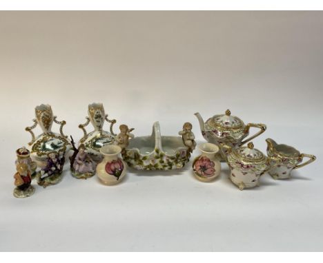 A Continental porcelain table centrepiece of Sitzendorf style, decorated with putti and measuring 22cm L, a pair of squat Moo