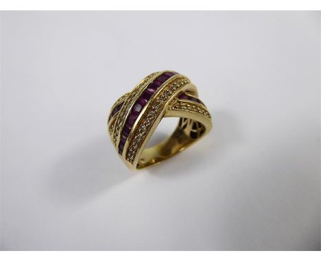 A 18ct Yellow Diamond and Ruby Cross-Over Ring, size P, approx 30 pts of dias, twenty six rubies, approx 13.5 gms.