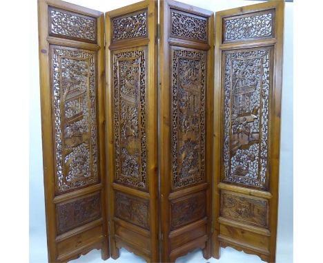 A Chinese Late 19th Century Hardwood Room Screen, with four panels intricately carved with a pagoda and a mounted figure retu