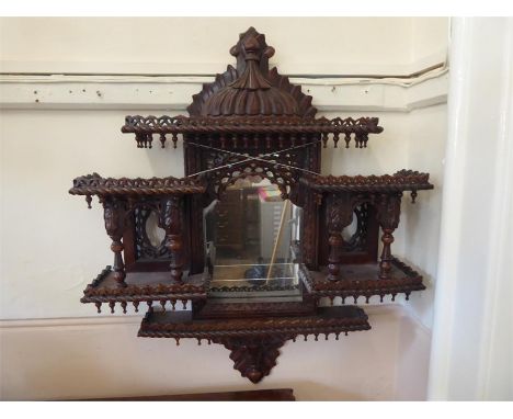 A Decorative Indian Intricately Carved Wall Mirror, depicting two compartments and a central mirror, approx 72 x 91 cms.  