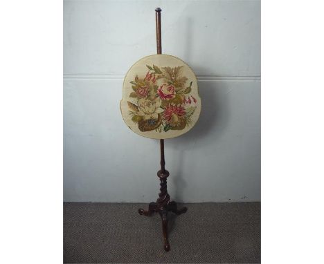 A Victorian Mahogany Firescreen, on turned support on tri-pod base. The needle point tapestry shield depicting fuchsias and r