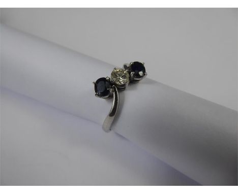 An 18ct White Gold, Diamond and Sapphire Ring. The ring set with a single brilliant cut diamond, approx 33 pts and two oval s