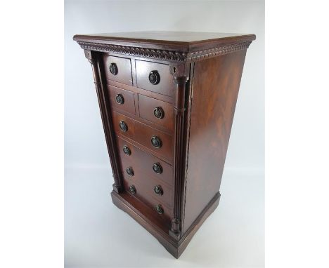 An Antique Mahogany Wellington Chest. The chest having four short and four long drawers with ring handles, two side columns t