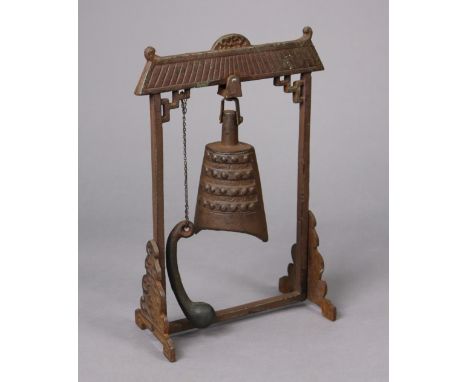 A Burmese cast-bronze table bell on a cast-iron stand (with beater), 25cm wide x 36.5cm high.