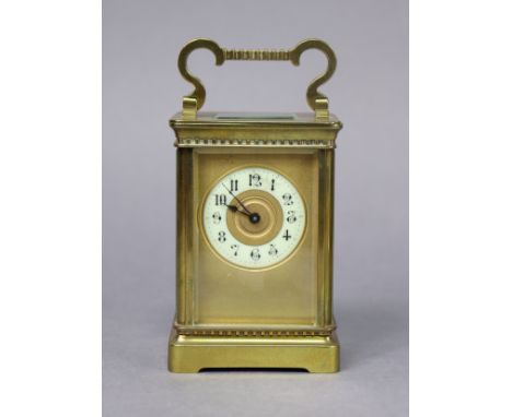 A late 19th/early 20th century brass carriage timepiece, the gilt dial with black Arabic numerals to the off-white enamel cha
