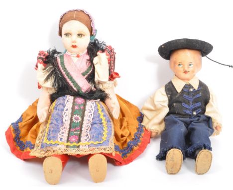 Two vintage dolls comprising a European folk inspired cloth body doll with painted face wearing a traditional dress with lace