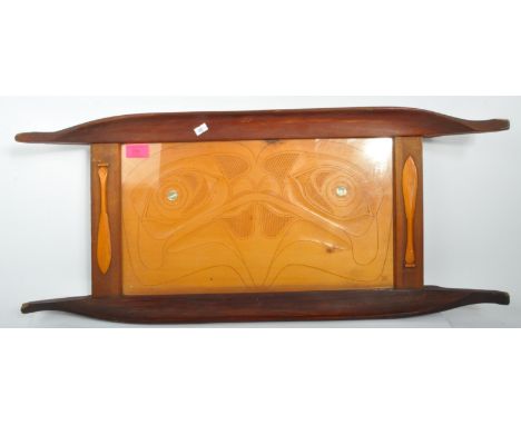 A 20th century Polynesian carved wooden tray. The tray having inlaid mother of pearl and paddles carved in relief. Measures 7