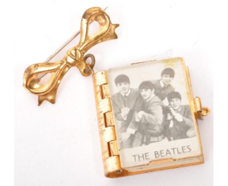 A vintage 20th century The Beatles pin badge brooch. In the form of a book with concertina photos of band members. Ringo Star