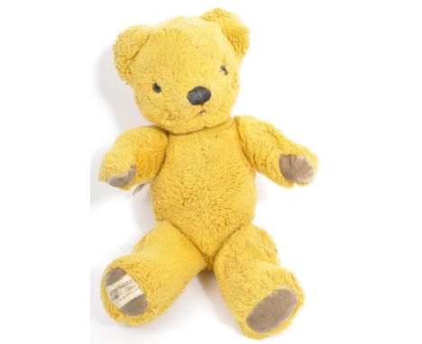 A small vintage Merrythought soft toy teddy bear. Golden plush fur with black / brown eyes and a stitched nose and mouth. Pad