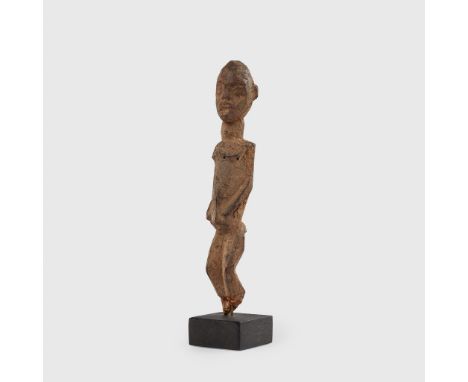 LOBI FIGURE BURKINA FASO carved wood, shown standing, the torso subtly turned, the hands placed on the belly, thick patinatio