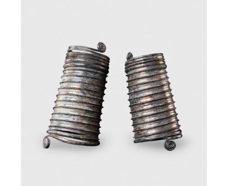 PAIR OF BRONZE AGE ARMBANDS EUROPE, 1200 - 900 B.C. copper alloy, each made from a single piece of continuous thread, with co