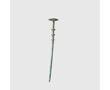 BRONZE AGE PIN EUROPE, 1500 - 1200 B.C. cast copper alloy, a rounded shaft with three ridges leading to a circular finial(18.