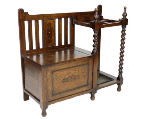 A mid 20th century stained oak hall stand, with integral seat and four division stick rack, 96.5 by 39.5 by 87.5cm high. 