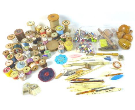 A collection of sewing and needlework items, including several bobbins, crocheting tools, reels of coloured threads, and smal