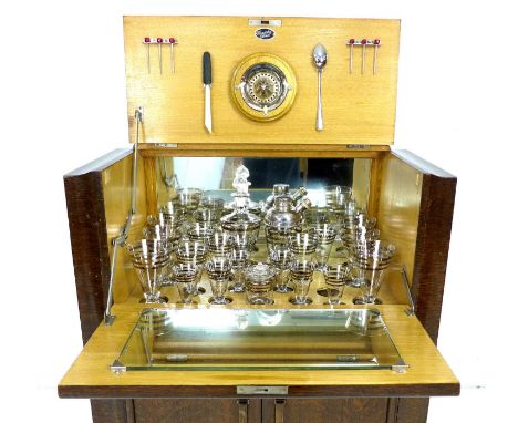A retro oak veneered cocktail cabinet, maker's label 'Hospitality Cabinet', the hinged top opening to reveal a drop down mirr