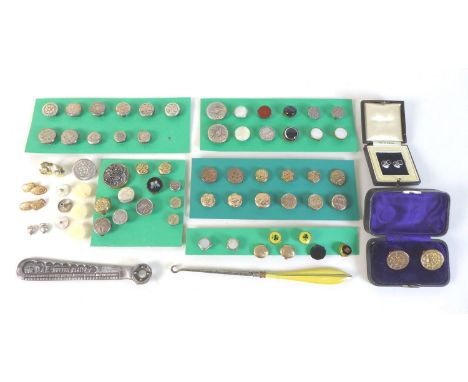 A collection of brass button studs, as well as a metal button hook and a metal device described as a button plate. (1bag) 