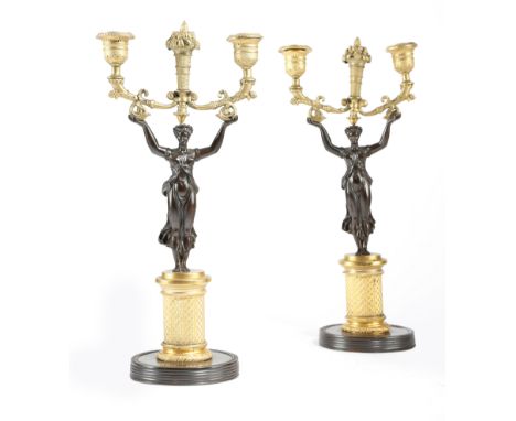 A PAIR OF FRENCH GILT PATINATED BRONZE FIGURAL TWIN-LIGHT CANDLESTICKS EARLY 19TH CENTURY each modelled with a classical maid