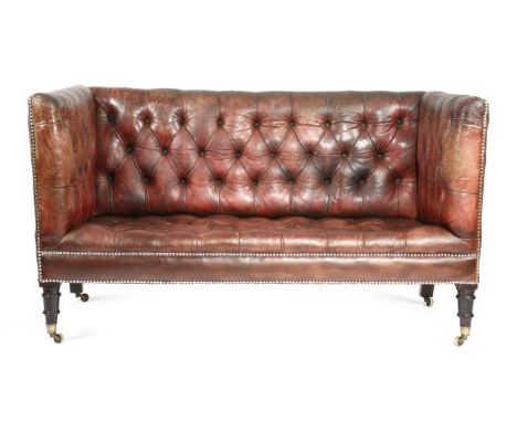 A RED LEATHER SOFA LATE 19TH CENTURY AND LATER with a studded and button upholstered back and seat, on turned front legs and 