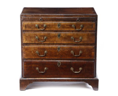 A GEORGE II WALNUT BACHELOR'S CHEST c.1740 the quarter veneered and crossbanded top inlaid with a parquetry star, with a cadd