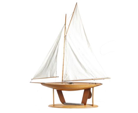 A LARGE POND YACHT LATE 19TH / EARLY 20TH CENTURY with a clinker built hull, cotton sails and brass mounts, on a later stand 