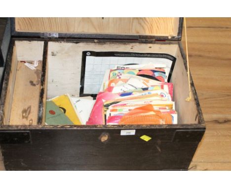 A black wooden trunk containing a selection of single records to include Elvis Presley, Herman's Hermits and Buddy Holy 