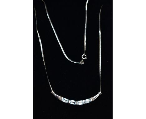 A 9CT GOLD, TOPAZ NECKLACE, a solid white gold crecent shaped bar, set with four emerald cut blue topaz stones, accented with