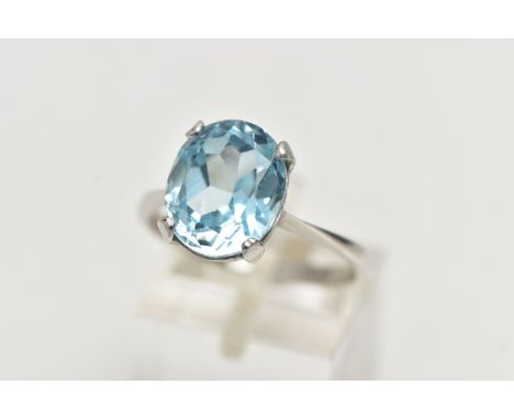 A MODERN 18CT GOLD TOPAZ RING, an oval cut light blue topaz, approximate dimensions length 12mm x width 10mm, four prong set 