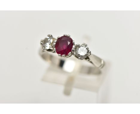 A PLATINUM RUBY AND DIAMOND THREE STONE RING, centering on an oval cut ruby, flanked with two round brilliant cut diamonds, e