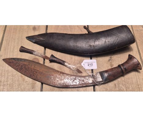 Antique Kukri Knife and sheath. Having smaller blades within the sheath. Wood handle and steel blade. Blade is rusted. 