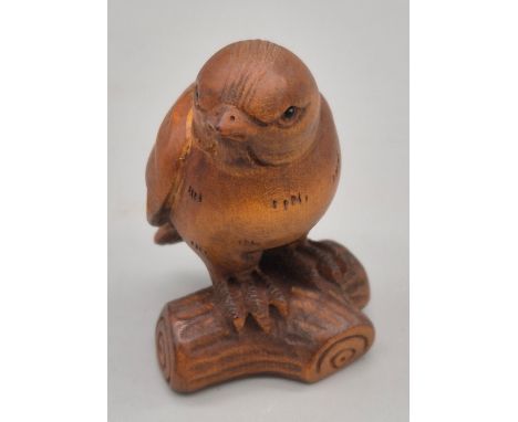 Japanese hand carved Boxwood Netsuke sculpture of bird perched on a branch. Fitted with black bead eyes and signed to the und