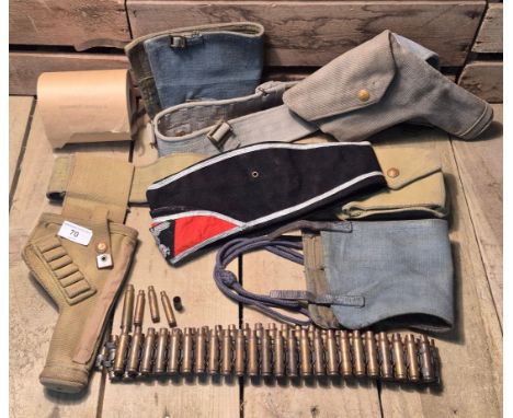 A Selection of military items; WW2 Gaters, Military issue toilet roll, Brass shells, WW2 Belts with holsters and German hat.