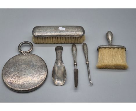 Six piece Sterling Birmingham Silver dressing table set; Hand mirror, two brushes, button hook, file and shoe horn.