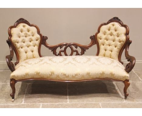 A Victorian walnut framed double spoon back sofa, in foliate pattern damask fabric, the twin button backs within a scalloped 