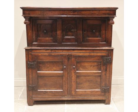 A William III oak joined court cupboard, the upper frieze carved with the initials 'K.E' and the year 1697 above turned bun p