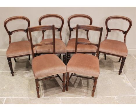 A set of four Victorian mahogany balloon back dining chairs, each with a stuff-over seat, upon lobed tapering front legs exte