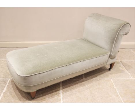 An Edwardian drop-end day bed, in green velour fabric, the padded scroll end with a reclining mechanism, upon mahogany legs o