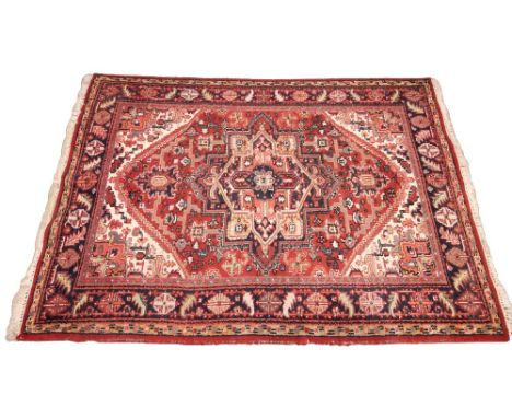 A vintage terracotta ground Persian Heriz rug, north Iran, in red, blue, green and ivory colourways, the central geometric me