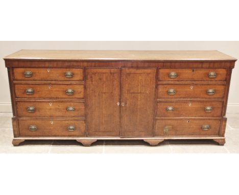 A George III oak and mahogany crossbanded Lancashire dresser base, of farmhouse proportions, the twin plank top over two cent