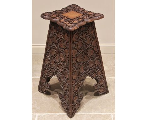 An Anglo Indian plant stand, early 20th century, overall carved in deep relief with trailing vinery and fruit, the shaped squ
