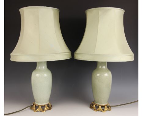 A pair of Chinese porcelain celadon lamp bases, each of baluster form and with incised floral decoration, gilt metal mounted,