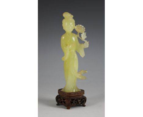 A Chinese jade figure of Lan Caihe, early 20th century, elegantly carved depicted wearing a flowing robe and holding a flower