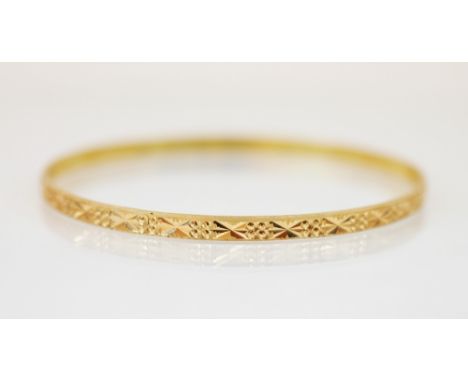 A Middle Eastern gold coloured bangle, with etched star decoration to exterior, Arabic character marked stamped to inside, 4m