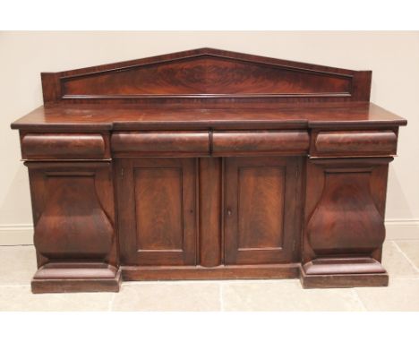 A mid 19th century inverted breakfront sideboard, the architectural raised back over three cushion moulded frieze drawers, an