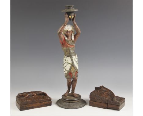 A cold painted spelter Egyptian Revival candlestick, late 19th or early 20th century, modelled as an incense bearer with arms