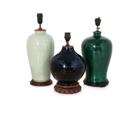 THREE CHINESE MONOCHROME PORCELAIN TABLE LAMPS
Comprising: a black glazed bottle vase, 19th Century, the neck cut down and ba