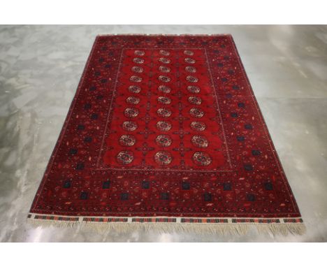 A LARGE TURKMEN BOHKARA WOOL CARPET (296 x 200cm)
Hand knotted wool pile, the central red field with three rows of octagonal 