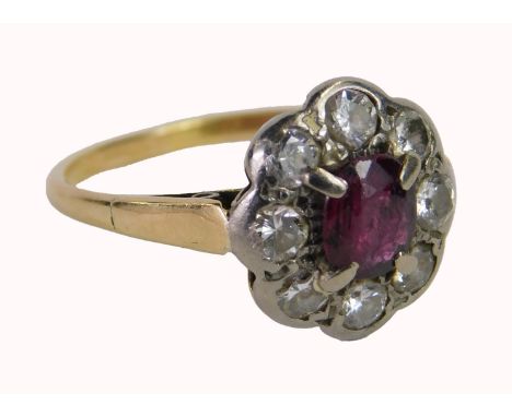 A ruby and diamond dress ring, set with oval cut ruby in four claw setting, surrounded by eight round brilliant cut diamonds,